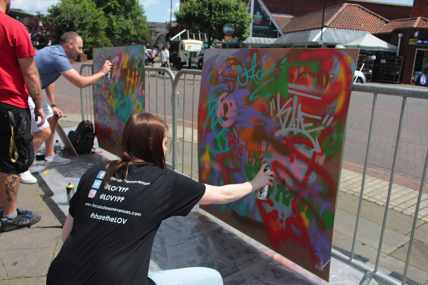 Young people spray painting canvas in Lincoln