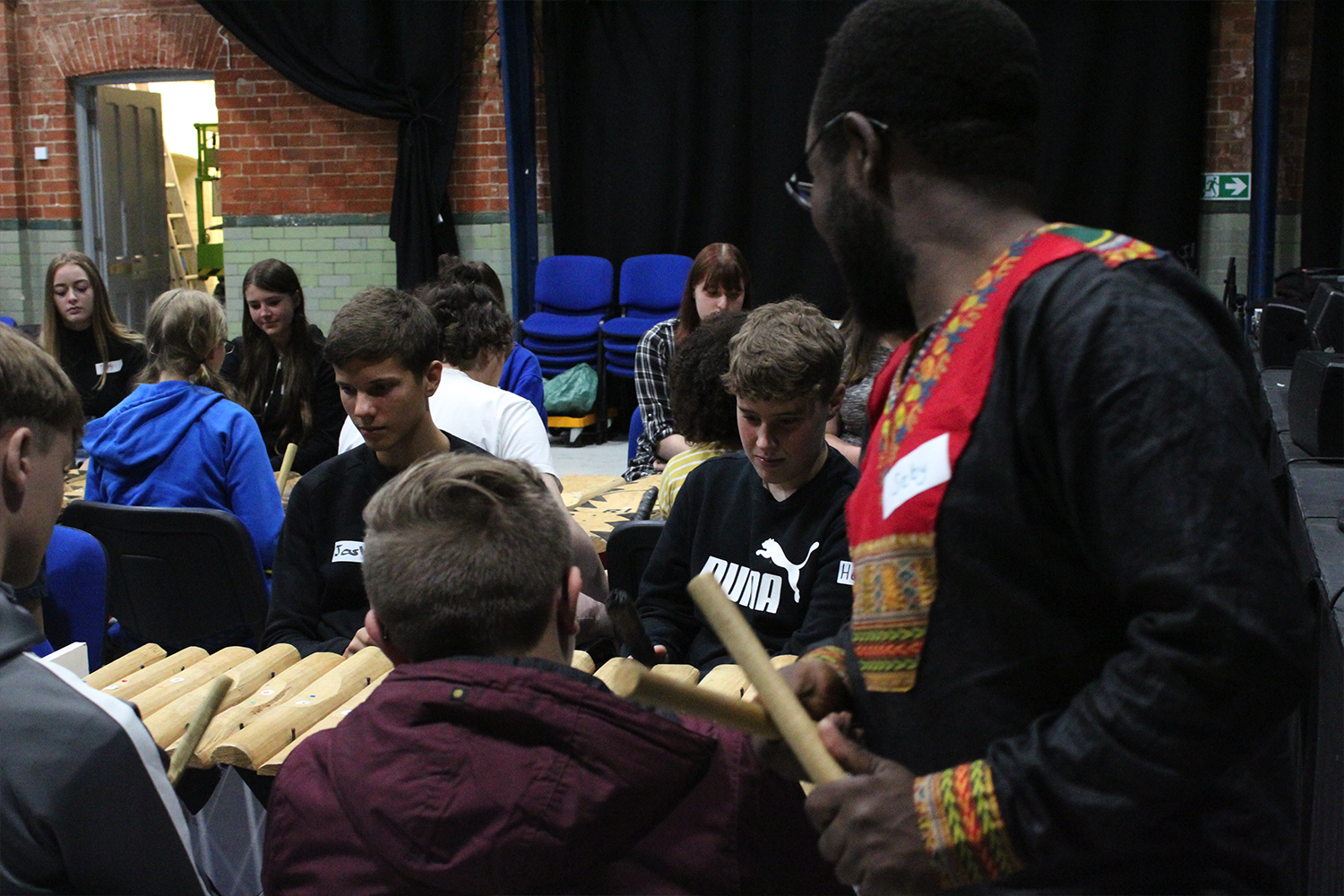 A music leader helps young Lincolnshire people play a marimba