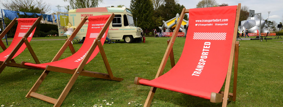Deckchairs on a lawn with the Transported Lincolnshire logo on